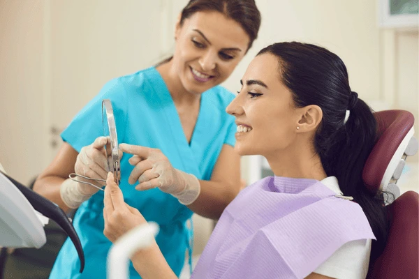A person looking at a mirror and whitening their teeth with a gentle Tamworth